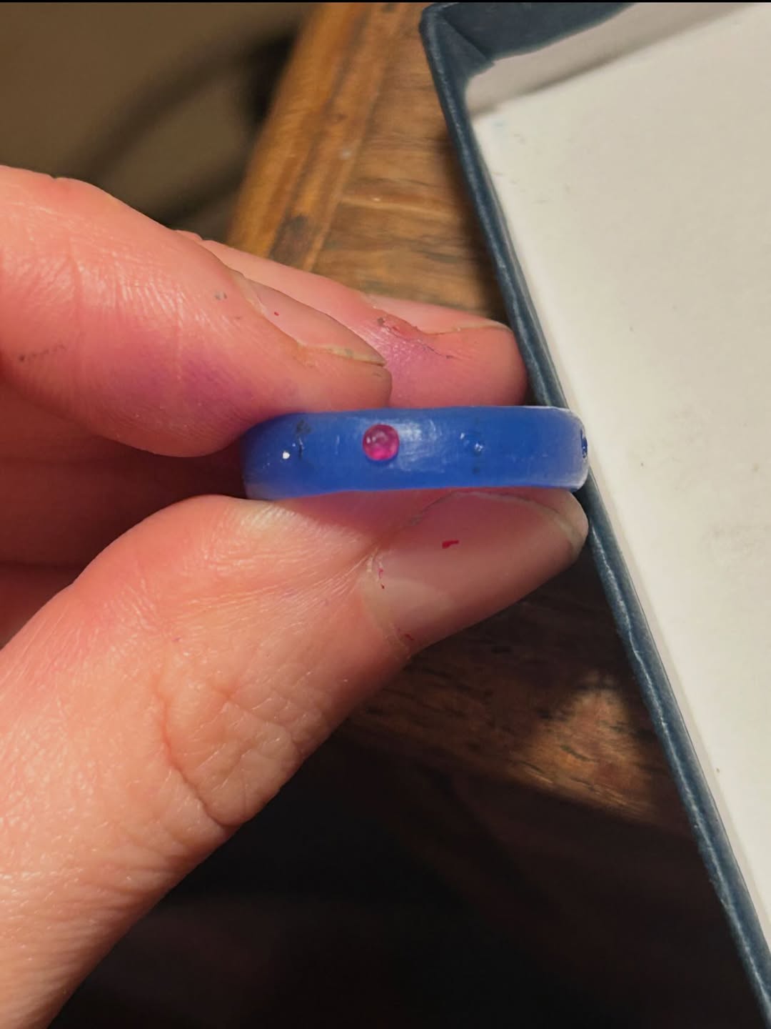 A blue carving wax ring model with a ruby set into the band
