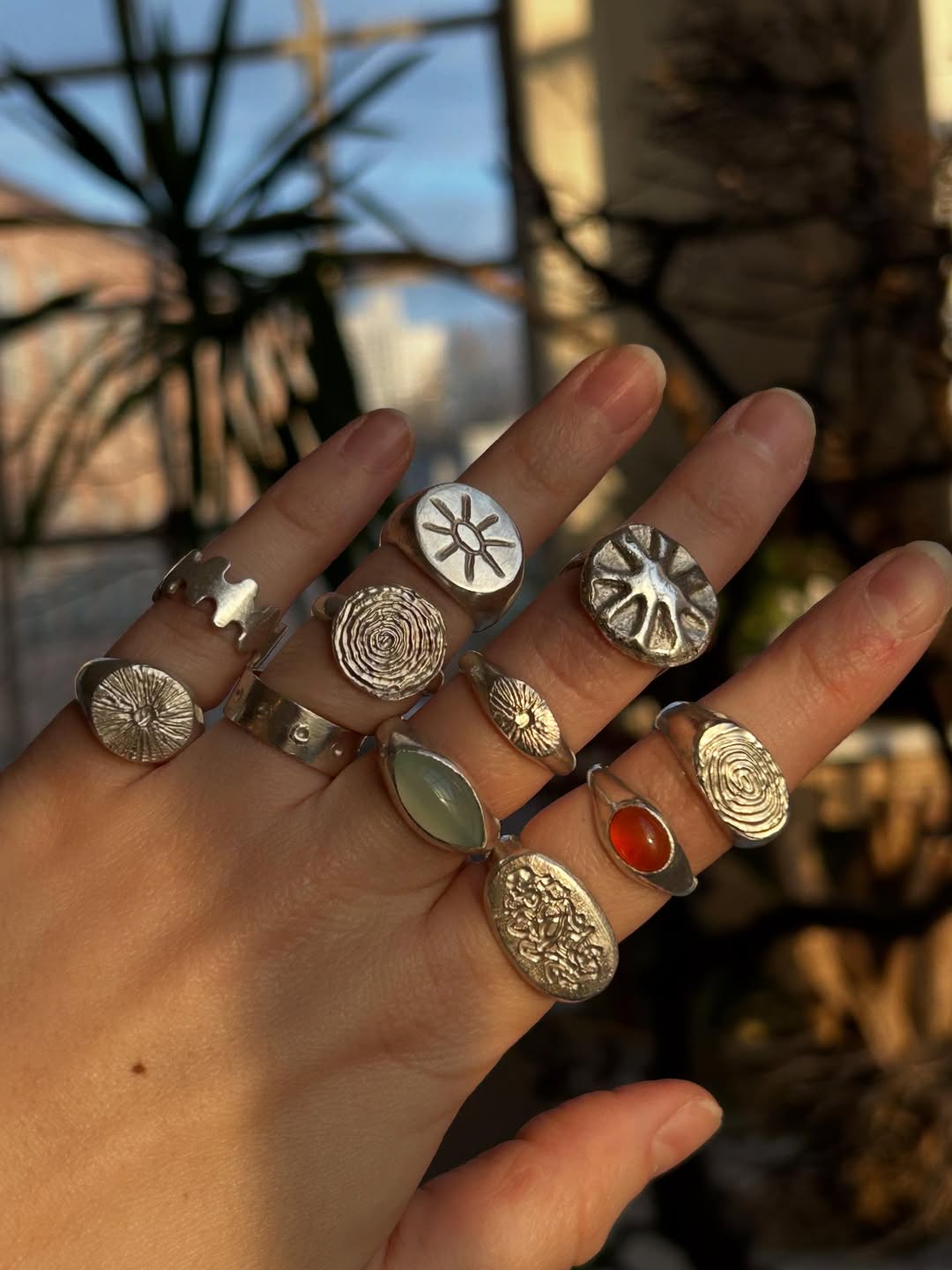 A handful of hand-carved silver signet rings with imprinted textures