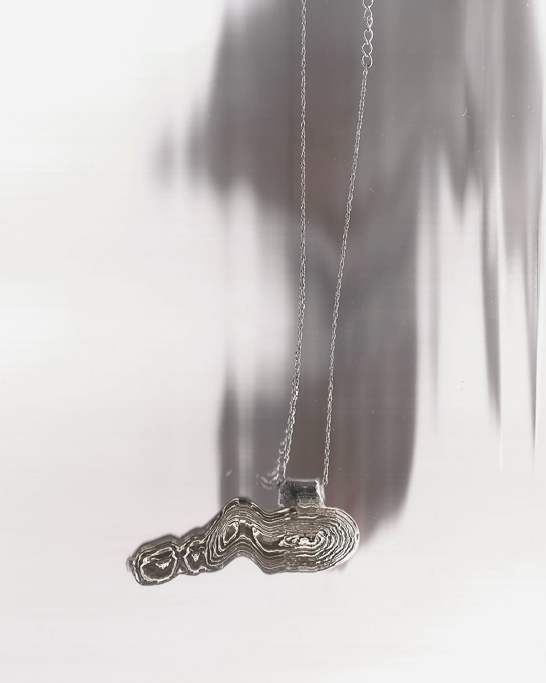 Hand-carved silver topographic pendant on a fine chain